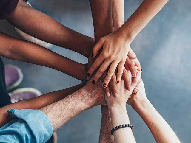 Photograph of hands joining together