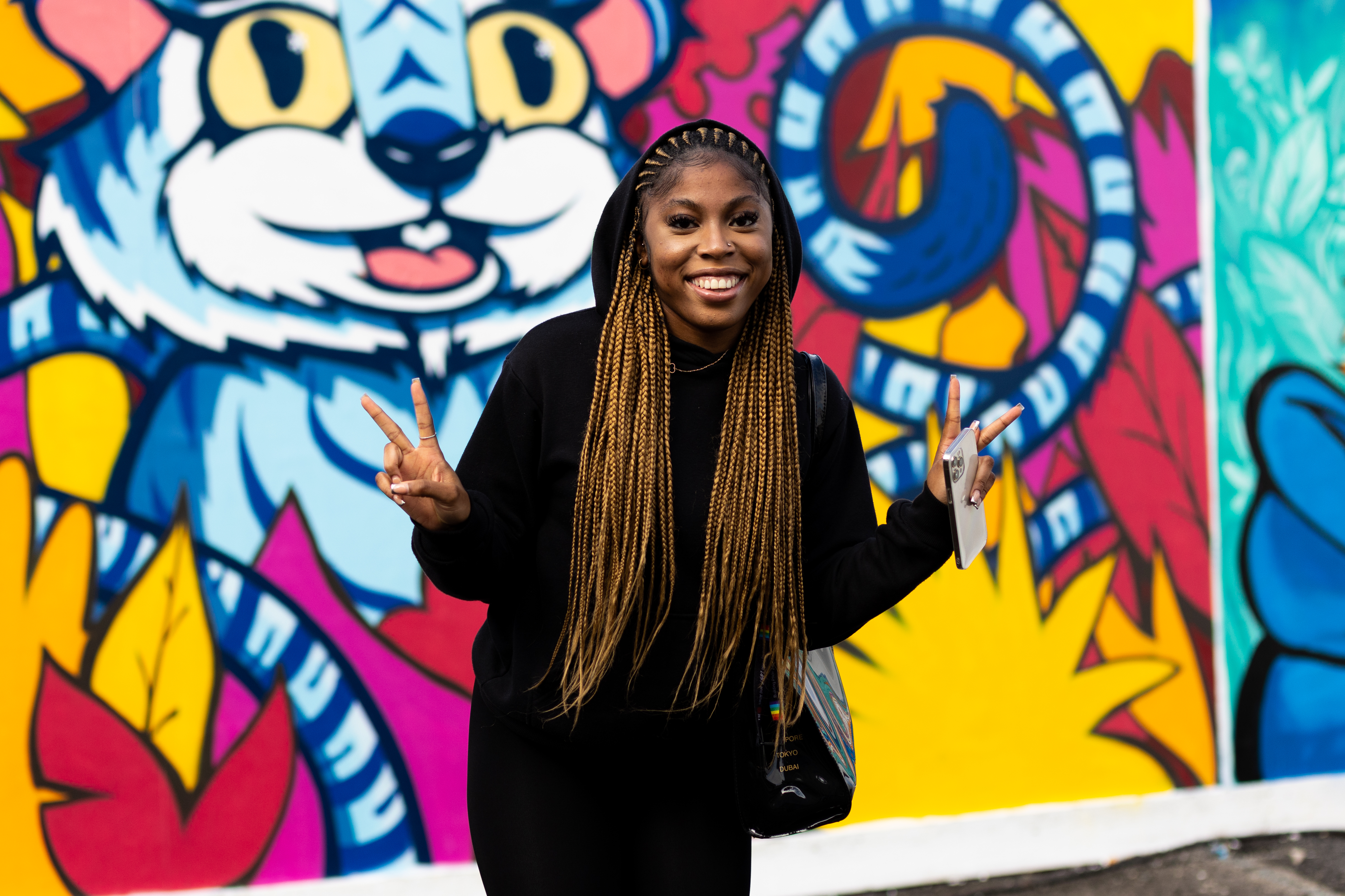 Student is smiling and signalling the peace sign