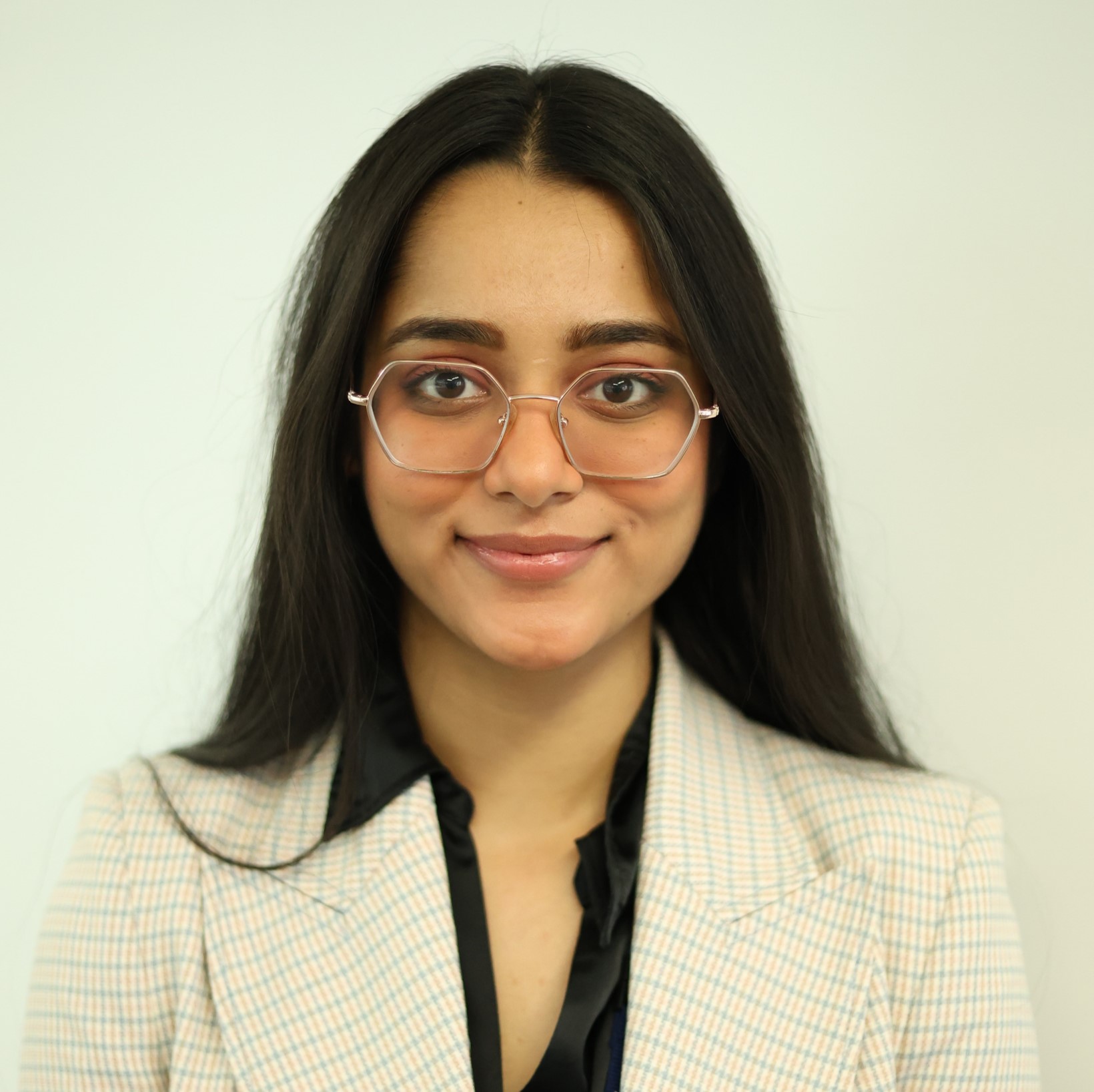 Ashween is wearing glasses smiling to the camera