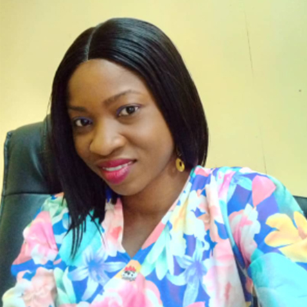 Bukola in a flower shirt smiling towards the camera