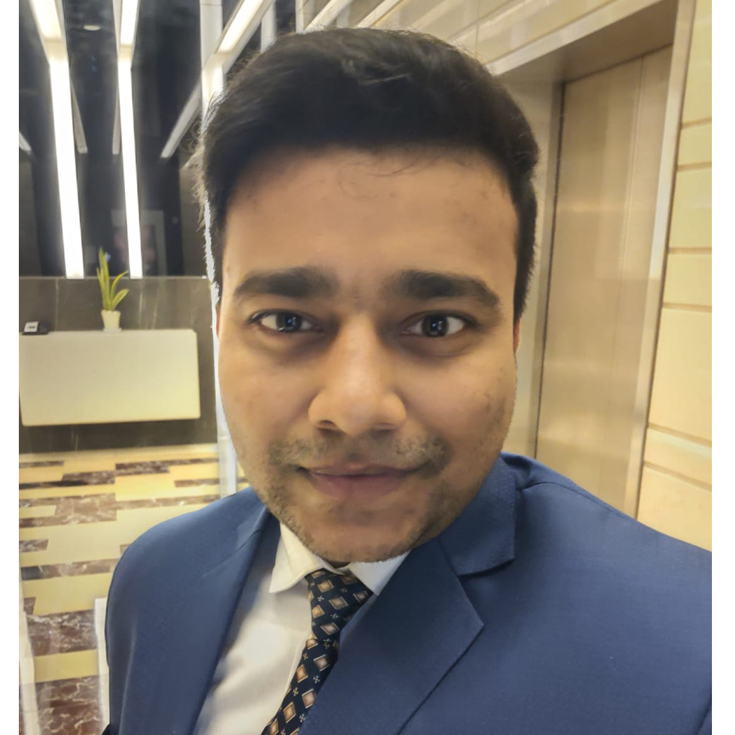 Harshal smiling into camera wearing a blue suit