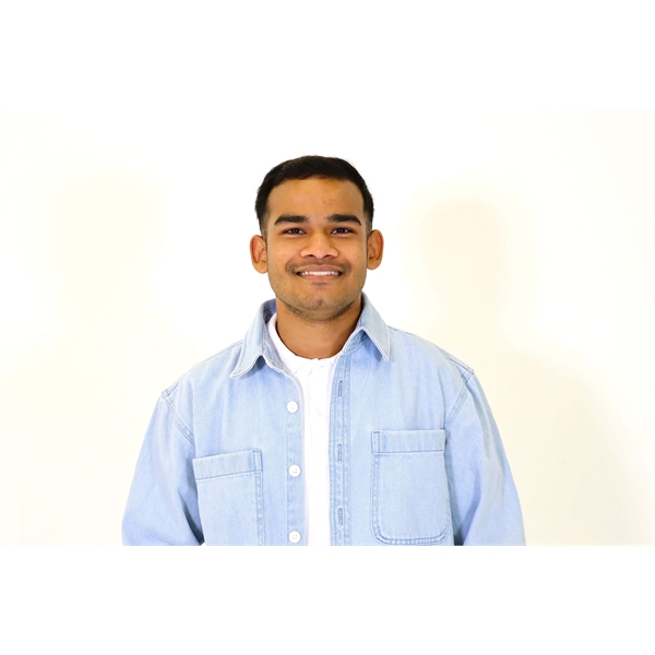 Craig has black hair and clean shaven and is in a blue shirt with a white t-shirt underneath