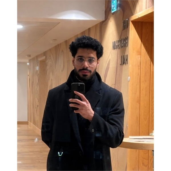 Mashror has black hair and a goatee beard taking a selfie wearing a black winter coat