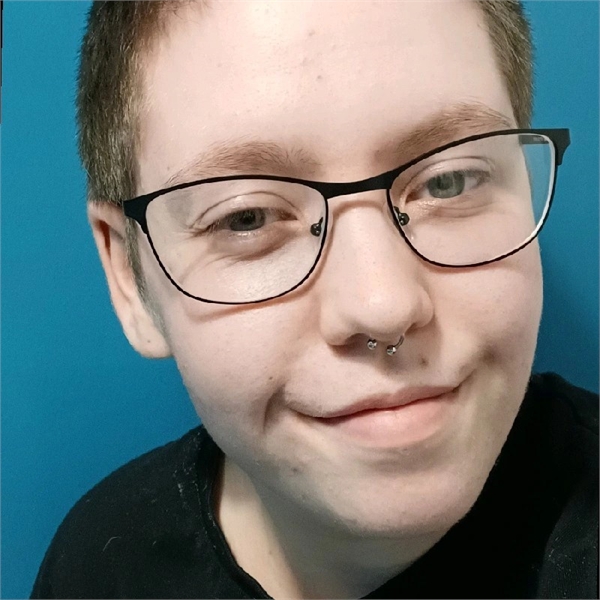 Ocean has brown hair and and is wearing glasses with a black t-shirt on