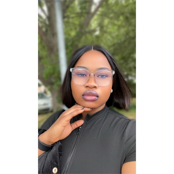 Ogbuefi is wearing a black top and has black hair whilst wearing glasses with her hand on her chin taking a selfie